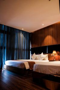 胡志明市标志精品酒店的一间卧室设有两张床和大窗户