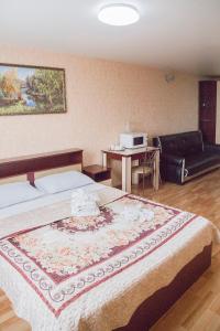 伊热夫斯克Hotel Mir的一间卧室配有一张床、一张桌子和一张沙发
