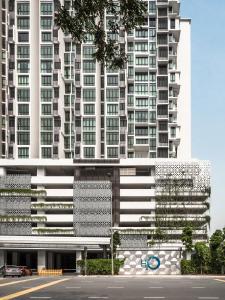 八打灵再也H20 Residence Ara Damansara by Airhost的一座高大的白色建筑,前面有一个停车位