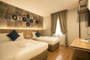 新山CIQ特鲁斯街酒店的酒店客房配有两张床和一张书桌