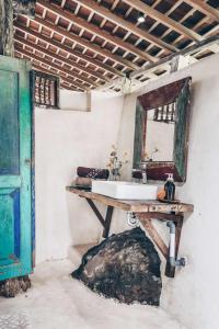 塔巴南Batukaru Coffee Estate的一间带水槽和桌子镜子的浴室