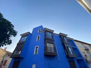 昆卡AT La casa Azul的一条蓝色的建筑,在街上有黑窗