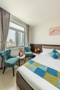 岘港Phuc Thanh Luxury Hotel by THG的一间卧室配有一张床、两把椅子和一个窗户