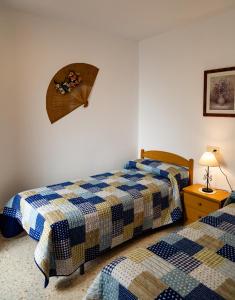 孔佩塔Apartamento Rural Antares的一间卧室配有两张床和一张带台灯的桌子