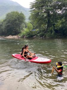 安吉县安吉 小森林 Little Forest Anji的两个女人坐在水中的桨板上