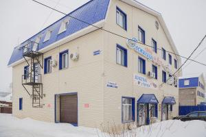 伊热夫斯克Hotel Mir的雪中带蓝色屋顶的白色建筑