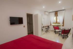 洛斯卡尼奥斯德梅卡Hostal Casa Arco Iris (Playa)的一间卧室配有红色的床和桌椅