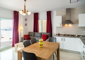 孔佩塔Apartamento rural Alborada的厨房以及带木桌和椅子的客厅。
