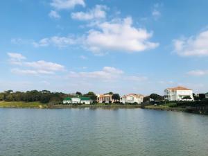 圣让-德蒙Studio du golf, standing, piscine, forêt et océan的享有湖泊美景,设有房屋