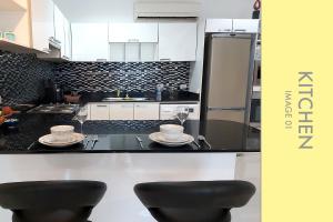 卡马拉海滩Pool Access 2 BDR Stylish Condo的厨房配有黑白橱柜和2张凳子