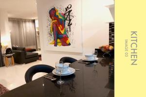 卡马拉海滩Pool Access 2 BDR Stylish Condo的一间设有桌子和墙上绘画的用餐室