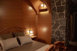 罗夫诺皮德科瓦酒店的一间卧室设有一张床和石墙
