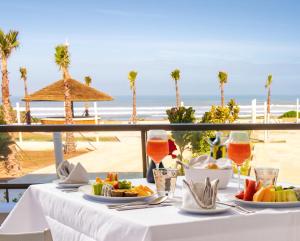 杰迪代Zephyr Mazagan的一张带食物的桌子,享有海滩美景