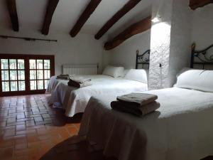 科尔努德利亚Molí dels Aubins的一间卧室配有两张带白色床单的床