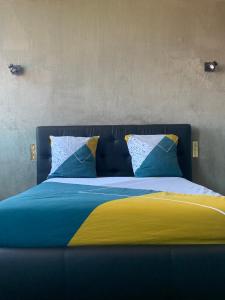 香槟沙隆L’ÉMERAUDE 4的一张带蓝色和黄色床单和枕头的床