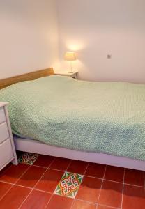 马赛Cabanon de Malmousque的卧室配有一张床和一盏灯,铺有瓷砖地板。