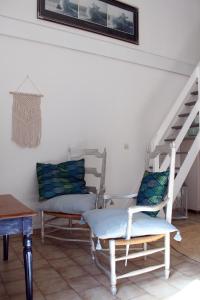 洛尔格Villa COLIBRI的一间带两把椅子和楼梯的客厅