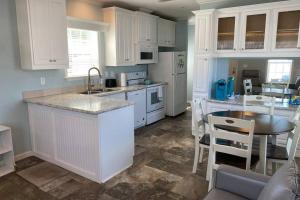基西米Cozy Tiny Home Near Disney World & Orlando Parks!的厨房配有白色橱柜和桌椅