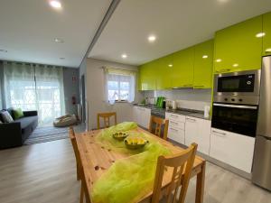 吉尔斯Cantinho Verde T1的厨房配有木桌和黄色橱柜。