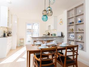 切尔滕纳姆10 Tivoli Mews - By Luxury Apartments的厨房以及带木桌和椅子的用餐室。