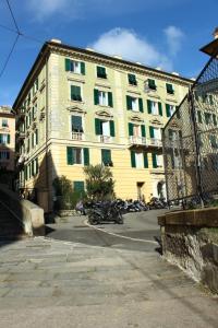 热那亚a due passi dal centro的一座大型黄色建筑,前面停有摩托车