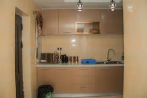 拉各斯Home Away from Home in Gowon Estate, Ipaja的厨房配有棕色橱柜和水槽