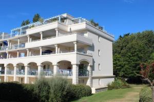 拉波勒Appartement de standing avec Piscine的一座大型白色建筑,设有阳台和树木