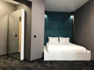 沃尔泽利SPA酒店的卧室配有白色的床和镜子