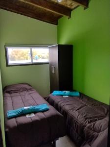 马拉圭MALARGUE STYLE,A 100 Mtrs DEL CENTRO,MUY UBICADO的绿墙客房内的两张床