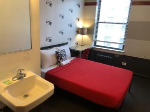 芝加哥芝加哥度假旅馆的一间设有红色床和水槽的小卧室