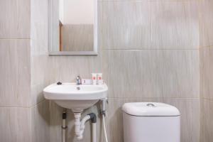 日惹OYO 1226 Al Abror Homestay的一间带水槽、卫生间和镜子的浴室
