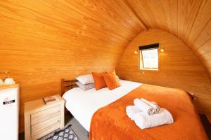 RuahineFlat Hills Tourist Park的木制客房内的一间卧室,配有一张床