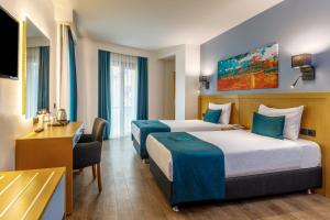 伊斯坦布尔Urban Hotel Bomonti的酒店客房配有两张床和一张书桌
