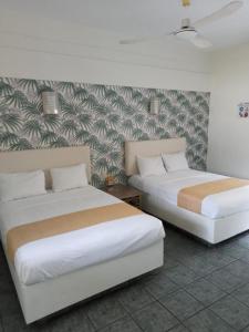 查察拉卡斯Hotel Gran Palmeiras的壁画客房内的两张床