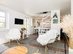 斯卡恩4 person holiday home in Skagen的客厅设有两把白色椅子和楼梯