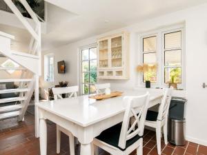斯卡恩4 person holiday home in Skagen的白色的用餐室配有白色的桌椅