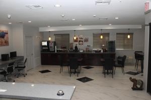 帕里斯Paris Inn & Suites的一间带椅子的客厅、一间厨房和一个酒吧