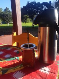 伊瓜苏港Cabañas El Despertar的咖啡壶和桌子上的一杯