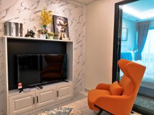 努沙再也Stay @ Almas Puteri Harbour的客厅配有橙色椅子和电视