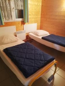 Presles-et-BovesAu Soleil de Picardie的木墙客房的两张床