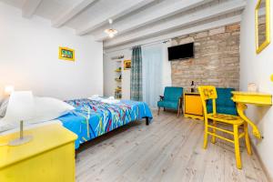 罗维尼Apartments & Rooms La casa Barbaro的一间卧室配有一张床、一张桌子和一张黄椅