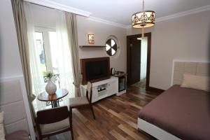 伊斯坦布尔K套房酒店的一间卧室配有一张床、一张桌子和一台电视