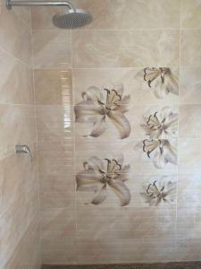 约翰内斯堡Elegant84的墙上设有带鲜花淋浴的浴室