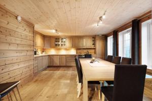 TjørhomKjerag Lodge的厨房以及带木桌和椅子的用餐室。