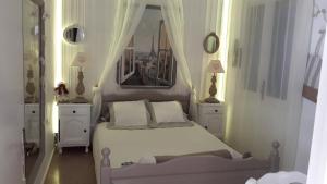 雷乌斯CHAMBRES D'HÔTES CHEZ CATHERINE A REUS chambre de Paris avec salle de bains privée的卧室配有白色的床和2个床头柜