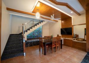 哥印拜陀SR Jungle Resort的一间带楼梯和桌椅的用餐室