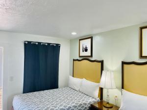 萨拉索塔Siesta Inn Sarasota - Indian Beach的一间卧室配有床和蓝色窗帘