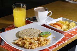 波帕扬Hotel Santa Maria的一小盘早餐食品,还有一杯橙汁