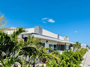 萨拉索塔Siesta Inn Sarasota - Indian Beach的前面有植物的白色房子