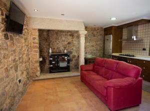 穆希亚Casal Rivas的客厅配有红色沙发和炉灶